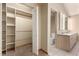 Walk-in closet leading to bathroom with dual vanity and toilet at 1060 S Eaton St, Lakewood, CO 80226