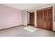 Carpeted bedroom featuring a closet, doorway, and pink wall at 1060 S Eaton St, Lakewood, CO 80226