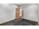 A simple room with gray walls and charcoal carpet, with an interior wood paneled door at 1060 S Eaton St, Lakewood, CO 80226