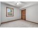 A bright bedroom features gray carpet, light gray walls, wood trim, and closet at 1060 S Eaton St, Lakewood, CO 80226