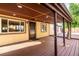 Covered deck featuring wooden flooring, recessed lighting, exterior security door and manicured garden views at 1060 S Eaton St, Lakewood, CO 80226
