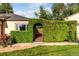 A covered entrance with a unique green hedge opening and stone walkway showcasing the home's charming curb appeal at 1060 S Eaton St, Lakewood, CO 80226