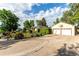 An exterior home view highlighting the large driveway, two-car garage with a basketball hoop and manicured greenery at 1060 S Eaton St, Lakewood, CO 80226