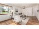 The well-lit living room features beautiful hardwood floors, neutral color palette, contemporary lighting and large windows at 1060 S Eaton St, Lakewood, CO 80226