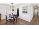 Inviting dining area with wood floors, modern lighting, and open view to the kitchen at 5060 S Fox St, Englewood, CO 80110