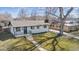 Inviting home with a cozy porch and lush, tree-filled yard, showcasing its curb appeal at 5060 S Fox St, Englewood, CO 80110