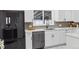 Bright kitchen featuring white cabinets, stainless steel appliances, and updated countertops at 5060 S Fox St, Englewood, CO 80110