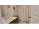 Bathroom featuring a shower-tub combo with white tile and a vanity with a large sink at 9279 Merino Ct # B, Littleton, CO 80125