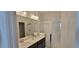 Bathroom featuring double sinks, modern fixtures, a walk-in shower, and a large mirror at 9279 Merino Ct # B, Littleton, CO 80125