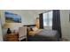 Cozy bedroom with a comfortable bed, desk, and a window with dark curtains at 9279 Merino Ct # B, Littleton, CO 80125