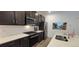Modern kitchen featuring stainless steel appliances, dark cabinetry, and bright white subway tile backsplash at 9279 Merino Ct # B, Littleton, CO 80125