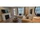 Bright living room with fireplace, featuring a comfortable sectional sofa and a cozy ottoman, perfect for relaxation at 9279 Merino Ct # B, Littleton, CO 80125