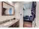 Bathroom with granite counters, wooden cabinets, and a view into the connected bedroom at 384 S Ironton St # 201, Aurora, CO 80012