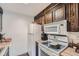 Cozy kitchen featuring wooden cabinets, laminate countertops and white appliances at 384 S Ironton St # 201, Aurora, CO 80012