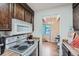 Galley kitchen with wood cabinets and an opening to the dining area with natural light at 384 S Ironton St # 201, Aurora, CO 80012