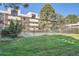 Community pool area behind a wrought iron fence featuring mature trees and grassy area at 384 S Ironton St # 201, Aurora, CO 80012