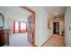 View into a bedroom from a hallway with a large window and red curtains at 9832 N Crystal Lake Dr, Littleton, CO 80125