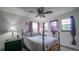 Cozy bedroom featuring a classic bed frame, ceiling fan, and abundant natural light at 9832 N Crystal Lake Dr, Littleton, CO 80125
