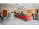 Spacious garage with a red car, shelving, and ample storage space at 9832 N Crystal Lake Dr, Littleton, CO 80125