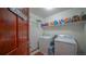 Functional laundry room with washer, dryer, and ample storage shelves at 9832 N Crystal Lake Dr, Littleton, CO 80125