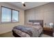 Cozy bedroom with a comfortable bed, large window, and modern wall accents at 5469 S Curtice St # L, Littleton, CO 80120