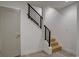 Stairwell with contemporary black horizontal railings, wood stairs, and a modern painted door at 5469 S Curtice St # L, Littleton, CO 80120