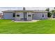 Home's backyard featuring a large lawn, a patio area, and a sliding glass door at 8481 Uinta St, Commerce City, CO 80022