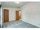Neutral carpeted bedroom featuring two doorways and a simple window with drapes at 8481 Uinta St, Commerce City, CO 80022