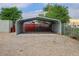 Metal carport structure with a concrete slab, gravel surroundings, and fenced perimeter at 8481 Uinta St, Commerce City, CO 80022