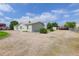 Single-story home exterior with a gravel lot, green bushes, and a carport at 8481 Uinta St, Commerce City, CO 80022