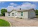 Charming single-story home featuring light green exterior, bright windows, and a gravel driveway at 8481 Uinta St, Commerce City, CO 80022
