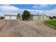 Single-story home with detached two-car garage and circular gravel driveway at 8481 Uinta St, Commerce City, CO 80022