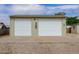 Detached two-car garage featuring two large garage doors and neutral siding at 8481 Uinta St, Commerce City, CO 80022