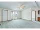 Bright living room with carpet flooring, a ceiling fan, and a window with patterned curtains at 8481 Uinta St, Commerce City, CO 80022