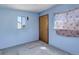 Light blue interior room with door, window, and patterned sheer curtain for privacy at 8481 Uinta St, Commerce City, CO 80022