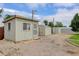 View of multiple storage sheds in the backyard with a gravel lot and blue skies at 8481 Uinta St, Commerce City, CO 80022