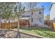 Spacious backyard featuring a covered deck, wooden fence, and lush greenery at 2415 E 110Th Dr, Northglenn, CO 80233