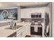 Well-lit kitchen features stainless steel appliances and white cabinetry at 2415 E 110Th Dr, Northglenn, CO 80233