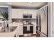 Well-lit kitchen features stainless steel appliances and white cabinetry at 2415 E 110Th Dr, Northglenn, CO 80233