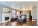 Open-concept living room with hardwood floors, fireplace, and adjacent dining area at 2415 E 110Th Dr, Northglenn, CO 80233