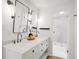Bright bathroom featuring a double vanity with marble countertops and modern fixtures, leading to a shower area at 6110 E 6Th Avenue Pkwy, Denver, CO 80220