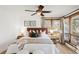 Cozy bedroom with a large window, ceiling fan, and a well-decorated bed with neutral tones and stylish pillows at 6110 E 6Th Avenue Pkwy, Denver, CO 80220