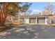Attractive home featuring an attached two-car garage and large driveway, framed by mature trees and landscaping at 6110 E 6Th Avenue Pkwy, Denver, CO 80220