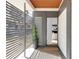Modern front entrance with gray siding, privacy screen, and a glimpse of the interior at 6110 E 6Th Avenue Pkwy, Denver, CO 80220