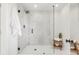 Modern bathroom featuring a glass-enclosed shower with marble tiling and black hardware, and a wooden bench for towels at 6110 E 6Th Avenue Pkwy, Denver, CO 80220