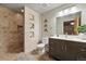 Bathroom features an earth-toned tiled shower with cubbies and a dark vanity at 2955 Inca St # 2D, Denver, CO 80202
