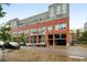 Modern red brick apartment building with visible covered parking and black trim at 2955 Inca St # 2D, Denver, CO 80202