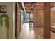 Hallway with exposed brick wall, wood flooring, a sliding barn door, and view to the main living area at 2955 Inca St # 2D, Denver, CO 80202