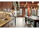 Modern kitchen with stainless steel appliances, concrete countertops, and exposed brick accent wall and wood beams at 2955 Inca St # 2D, Denver, CO 80202