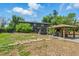 Large backyard boasts mature landscaping, a gazebo with seating, and exterior view of home at 6505 W Hampden Ave, Lakewood, CO 80227
